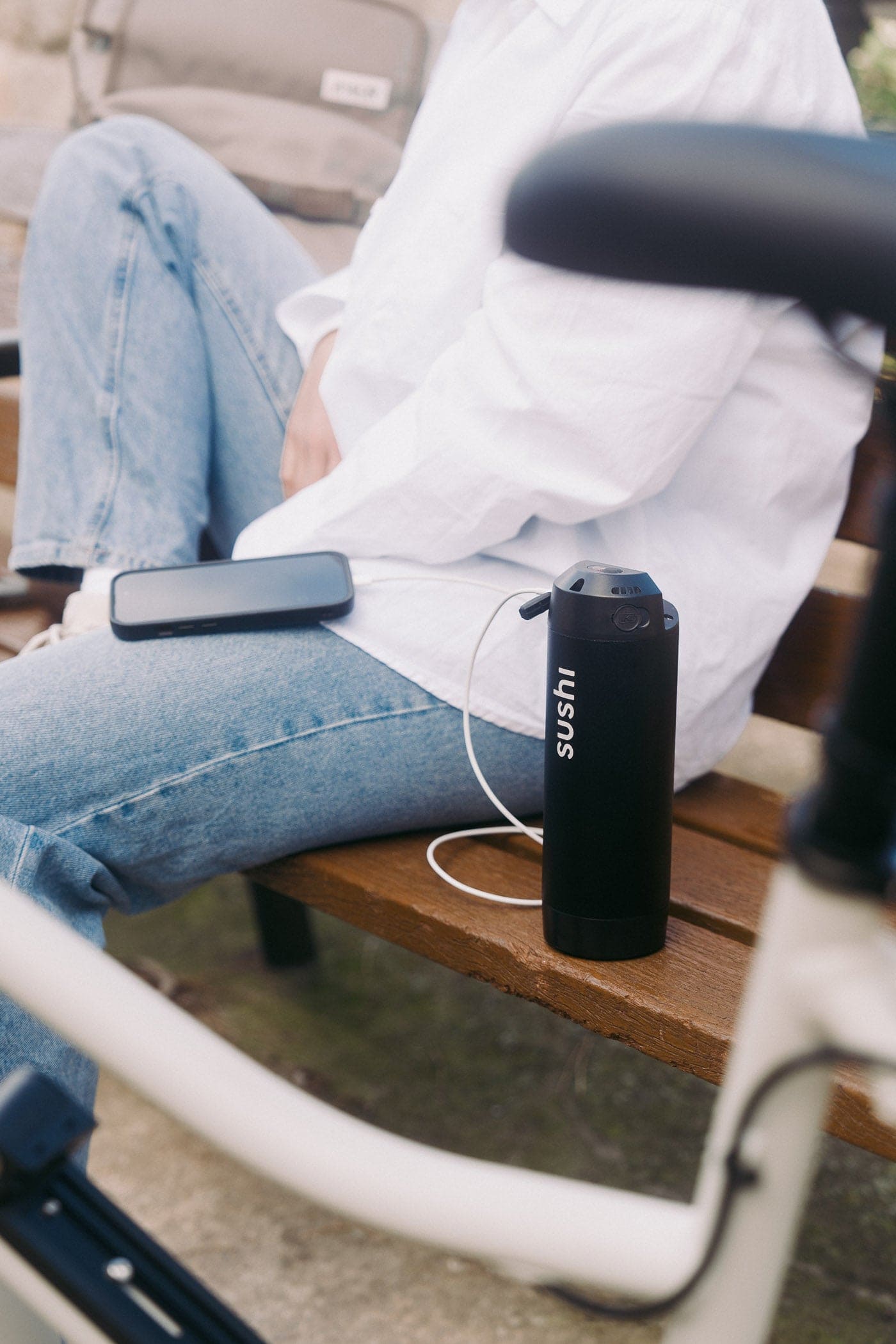 Sitting next to Bike charging Smartphone with removable Battery