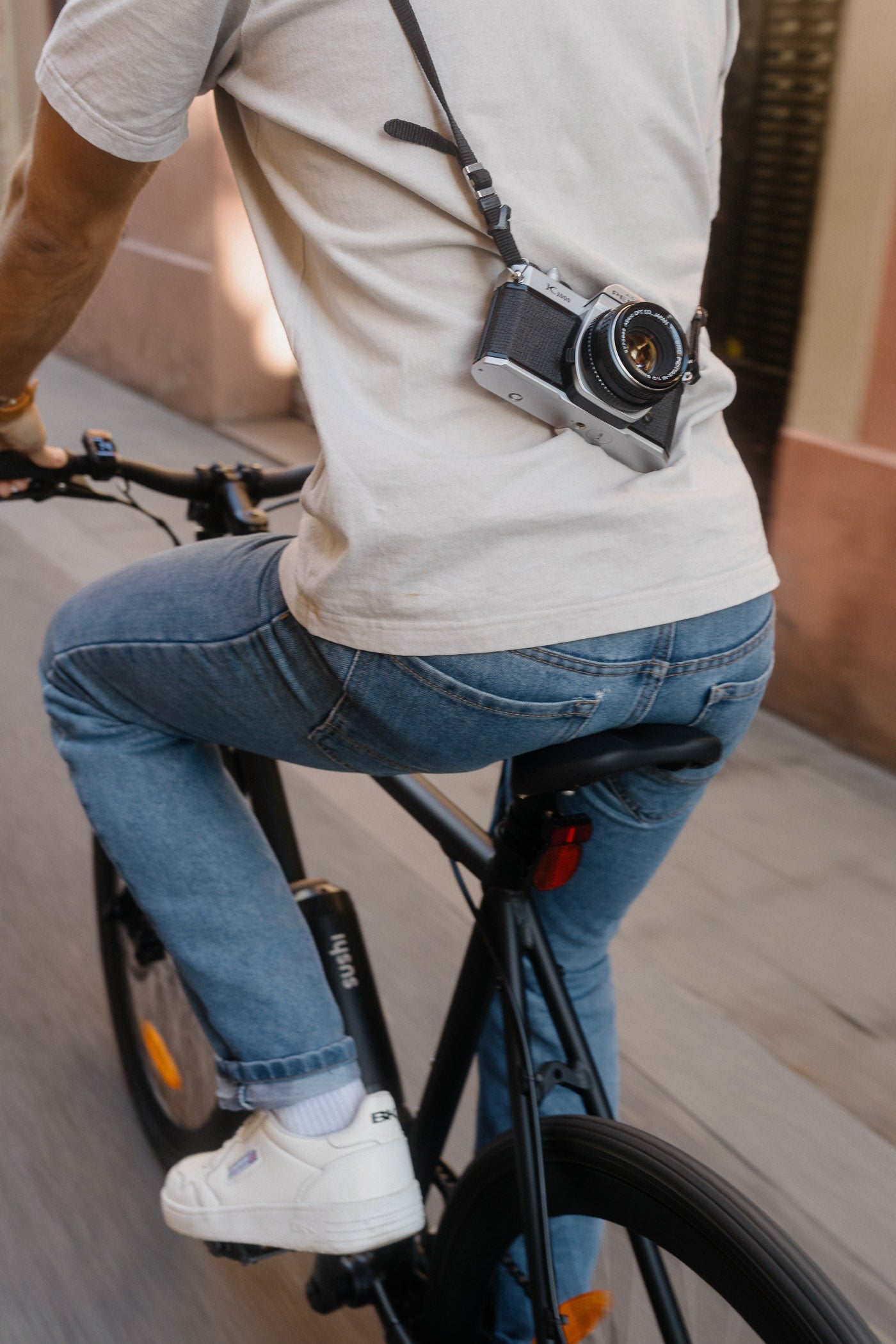 Mann fährt auf schwarzen E-Bike Maki 3.0, nur der Unterkörper von hinten ist zu sehen