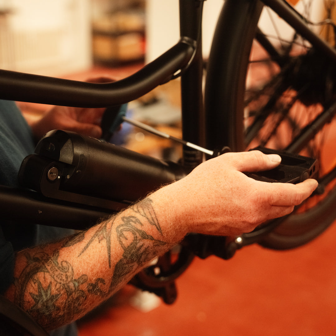 Detailaufnahme: E-Bike-Pedal wird an einem SUSHI BIKES montiert – Handarbeit für nachhaltige Mobilität