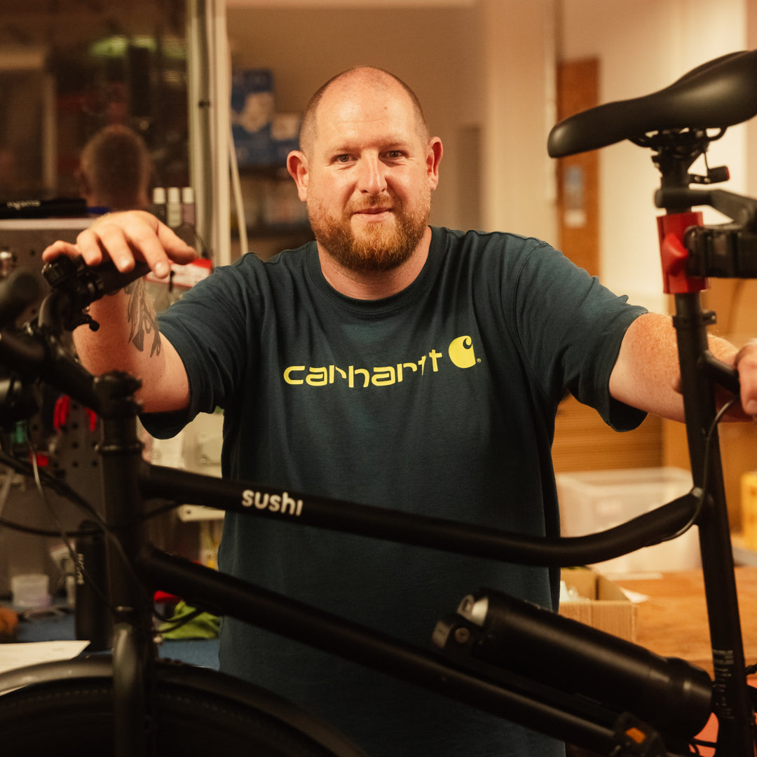 SUSHI BIKES Bike-Experte Sebastian arbeitet an schwarzem E-Bike in der Werkstatt