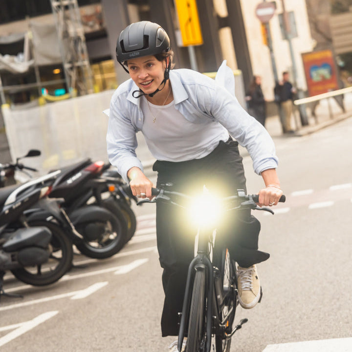 Person fährt Rad in der Stadt und trägt den weißen Lazer CityZen KinetiCore Helm, frontal fotografiert