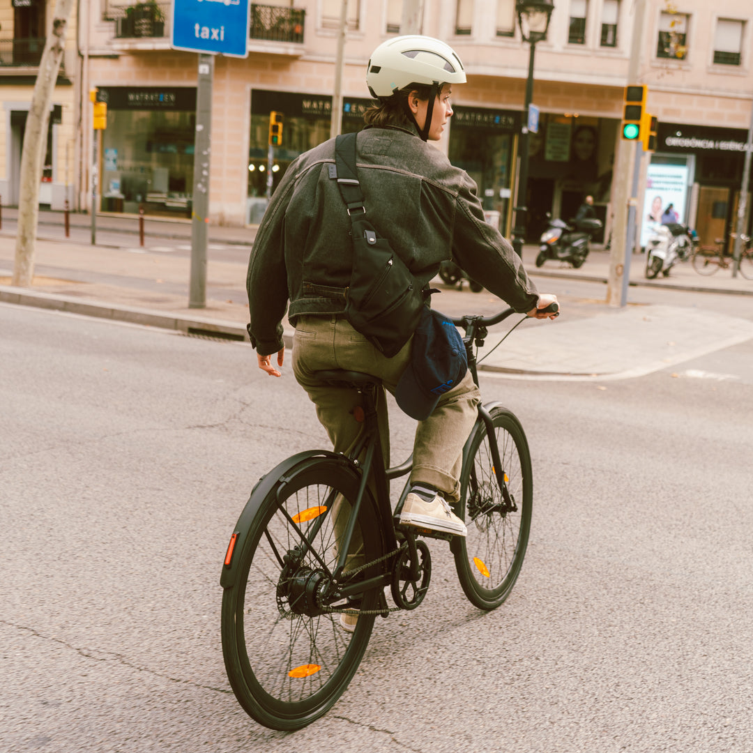 Frau mit Helm fährt auf einem E-Bike von SUSHI BIKES durch die Stadt