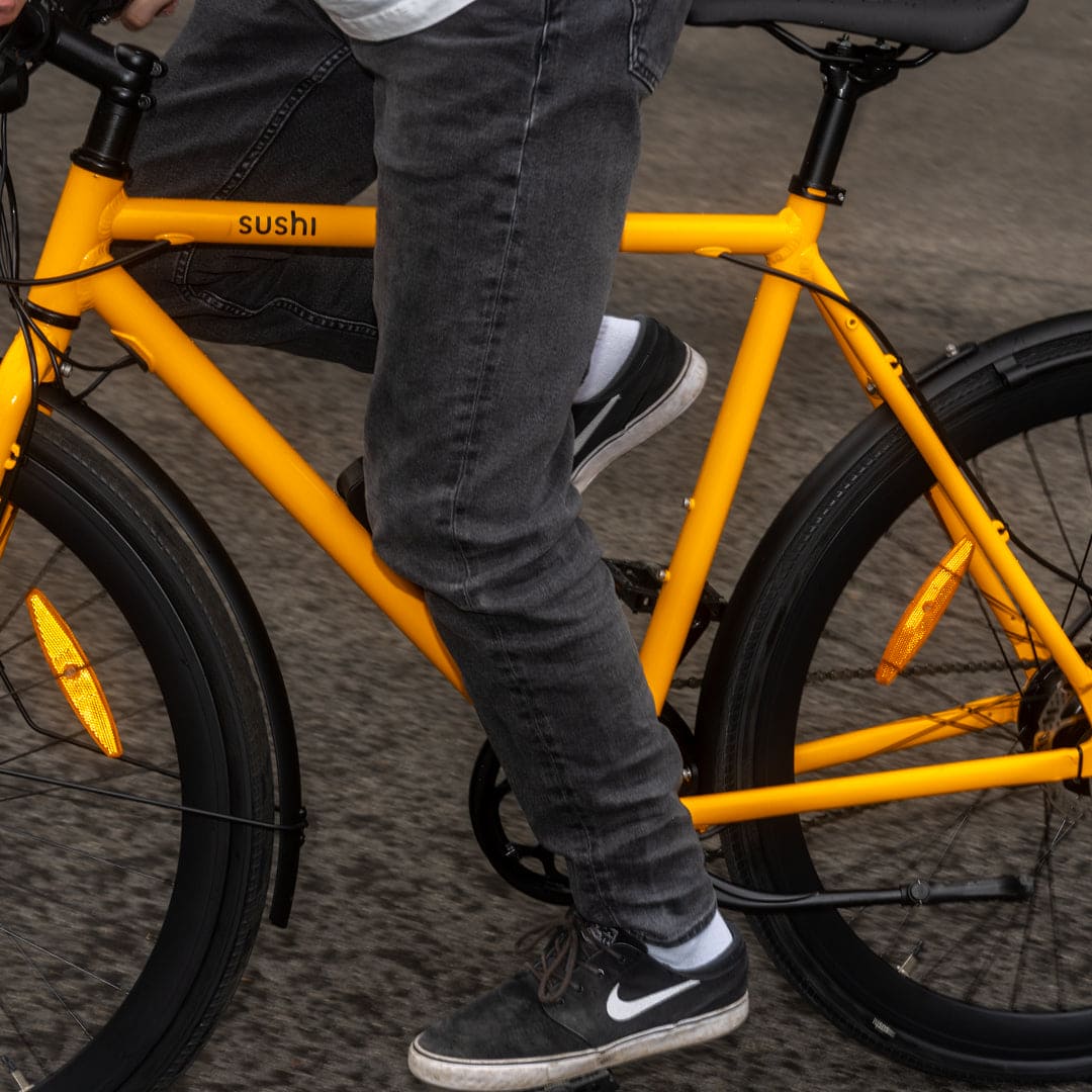 Maki 3.0+ Lava, Detailaufnahme des gelben E-Bikes während der Fahrt, Fokus auf Rahmen und Pedale