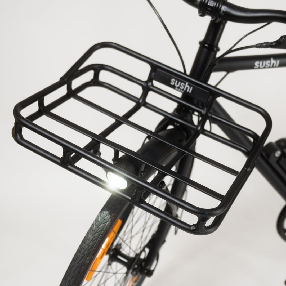 Schwarzer Frontgepäckträger am Sushi Bike, über dem Vorderrad montiert, mit darunter befestigtem LED-Licht