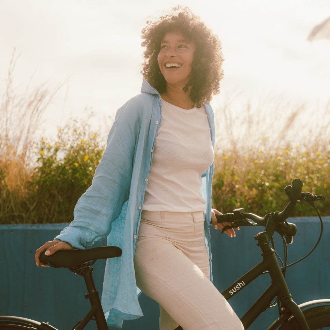 Frau lächend mit E-Bike von SUSHI BIKES im Sonnenlicht