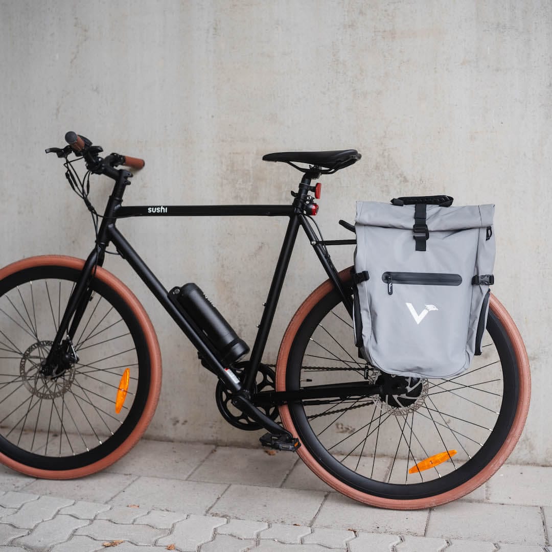 Grau reflektierende ValkOne Tasche am Gepäckträger eines E-Bikes von SUSHI BIKES befestigt