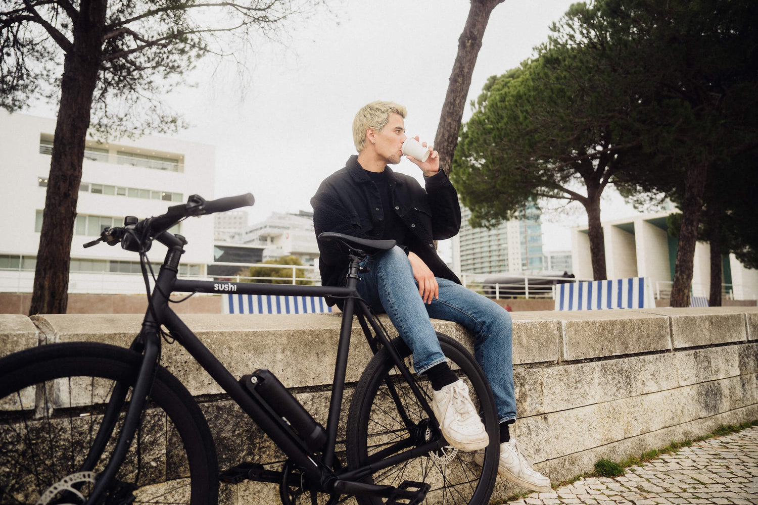 Mann sitzt neben versichertem schwarzen Sushi Bike