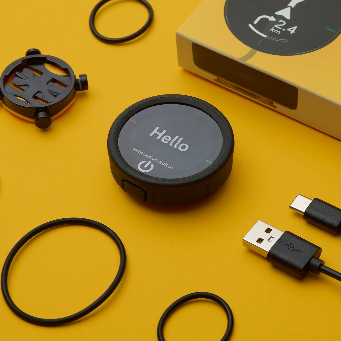 Übersicht des Lieferumfangs bestehend aus Beeline Velo 2 Fahrradcomputer, USB-C Ladekabel, Universalhalterung mit Gummibändern, Schnellstartanleitung 