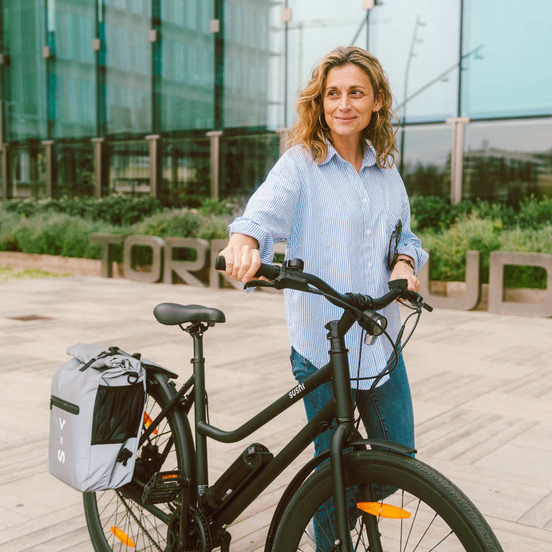 Lächelnde Frau schiebt schwarzes California Roll 3.0+ mit montierter Fahrradtasche