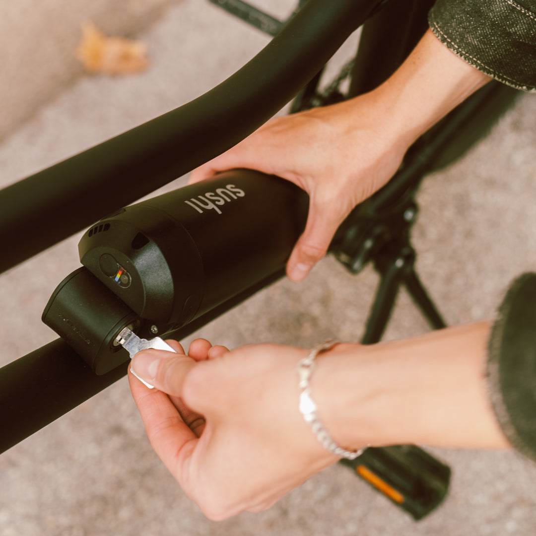 Herausnehmbarer E-Bike-Akku mit USB-C-Anschluss, wird aus dem Rahmen eines SUSHI BIKES entnommen
