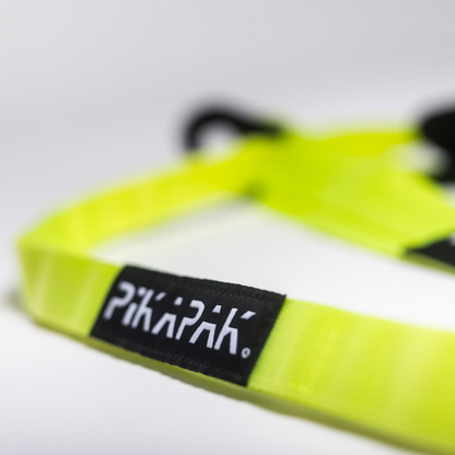 Nahaufnahme des reflektierenden PIKAPAK-Schriftzugs auf neongelbem Gurtband