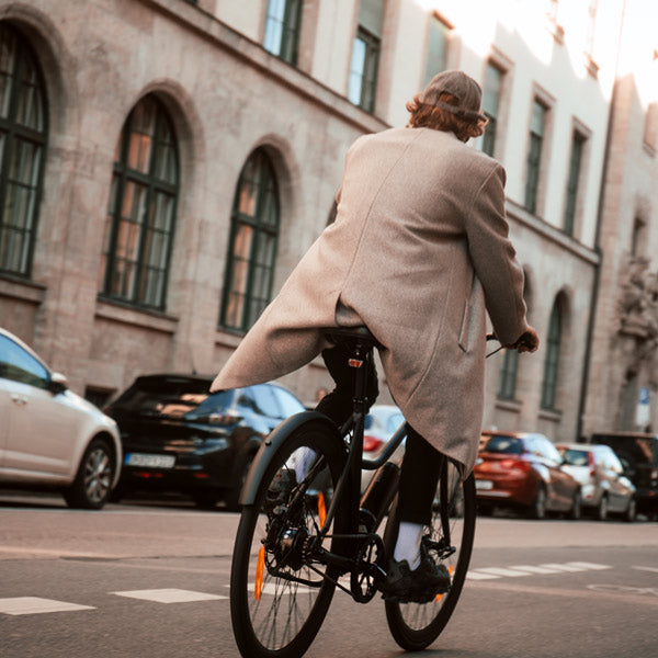 Mann fährt mit einem SUSHI BIKE durch die Stadt. Das motorisierte E-Bike beschleunigt dabei in verschiedenen Stufen.
