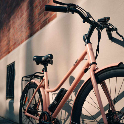 Schwarzer Komfortsattel auf montiertem SUSHI BIKE in Rosa vor heller Hauswand