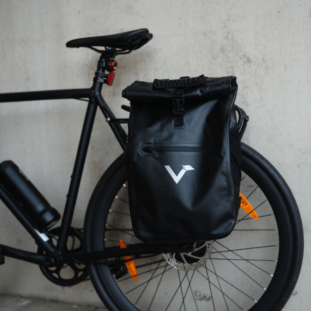 Schwarze ValkOne Fahrradtasche seitlich am Gepäckträger eines schwarzen E-Bikes von SUSHI BIKES befestigt