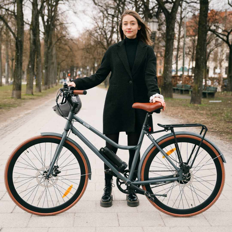 Junge Frau präsentiert graues Sushi E-Bike 